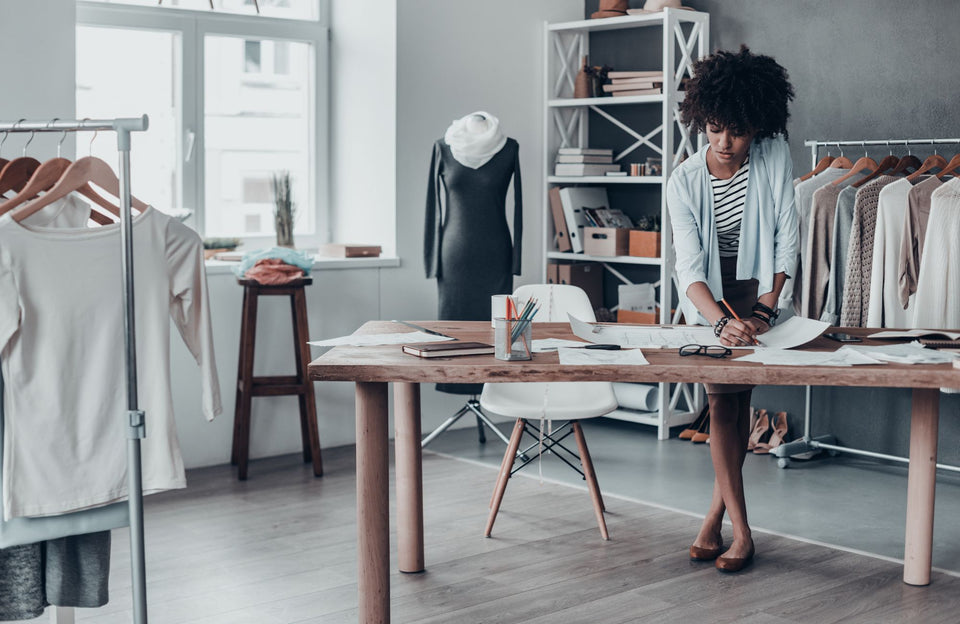 a tailor working on drawings in her studio
