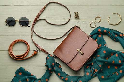  a tan belt and bag teamed with a green spotted scarf and accessories