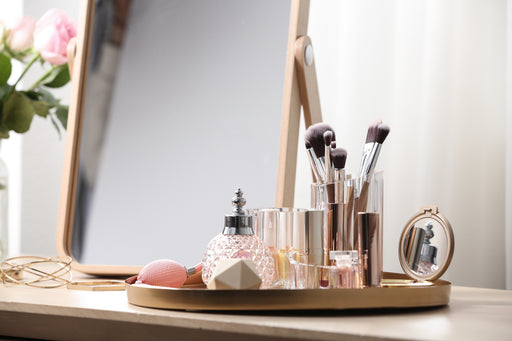 a tray with perfume bottles and make up brushes in a container