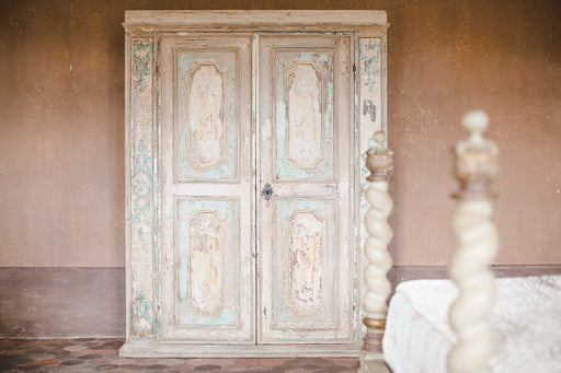 a very old distressed wooden armoire