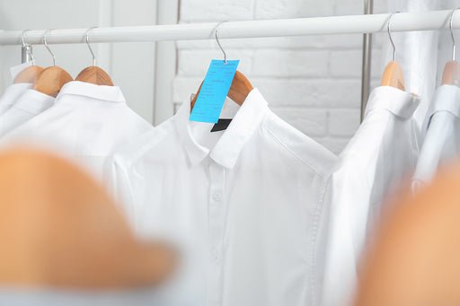 a white shirt with a dry cleaning ticket on a hanger