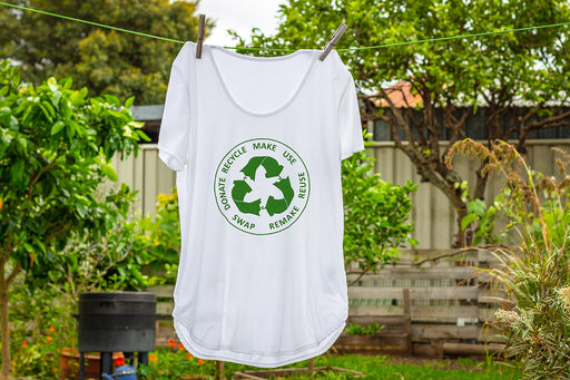 a white t-shirt with a recycle logo on it, hanging on a washing line