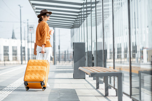 a woman at the airport with a four-wheeled suitcase