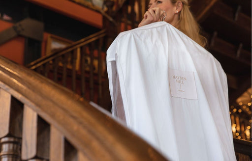 a woman carrying a Hayden Hill Long Hanging Bag up stairs in a hotel