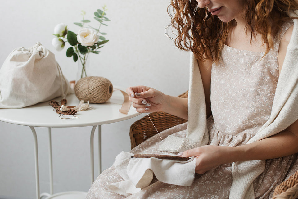 a woman hand embroidering linen