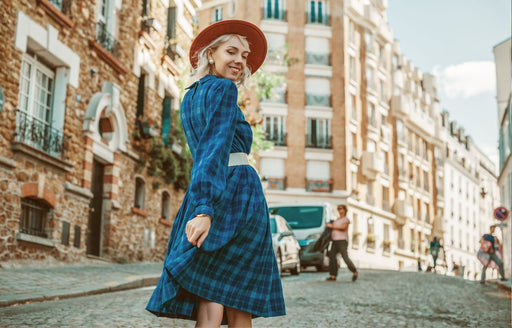 a woman in a checked blue dress with a white belt