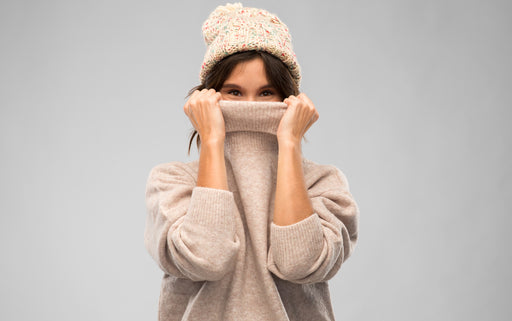 a woman in a cosy pullover and woollen hat