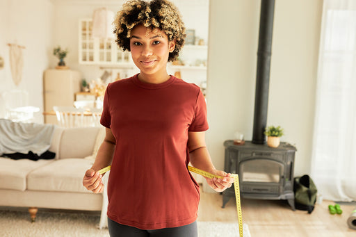 a woman measuring her waist with a tape measure