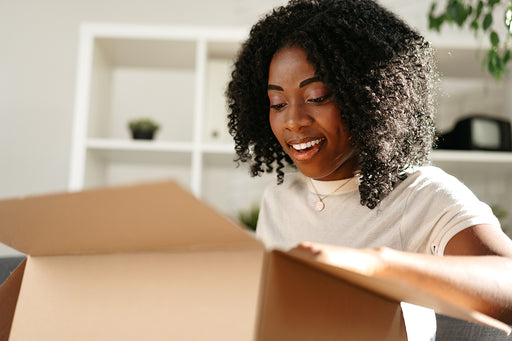 a woman opening a box of clothing that she ordered online