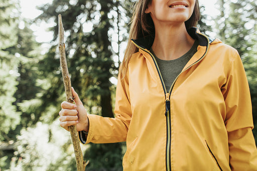 a woman outdoors in a zippered yellow jacket