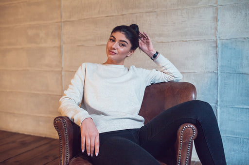 a woman relaxing in a white sweatshirt and dark navy denim pants