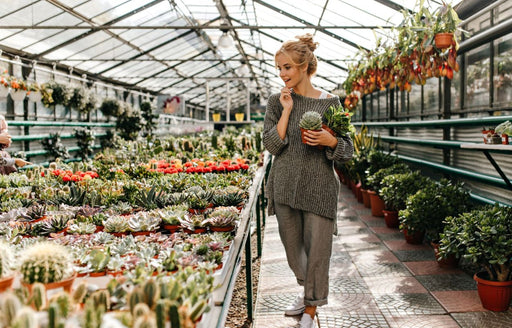 a woman wearing a baggy sweater and pants, shopping for plants