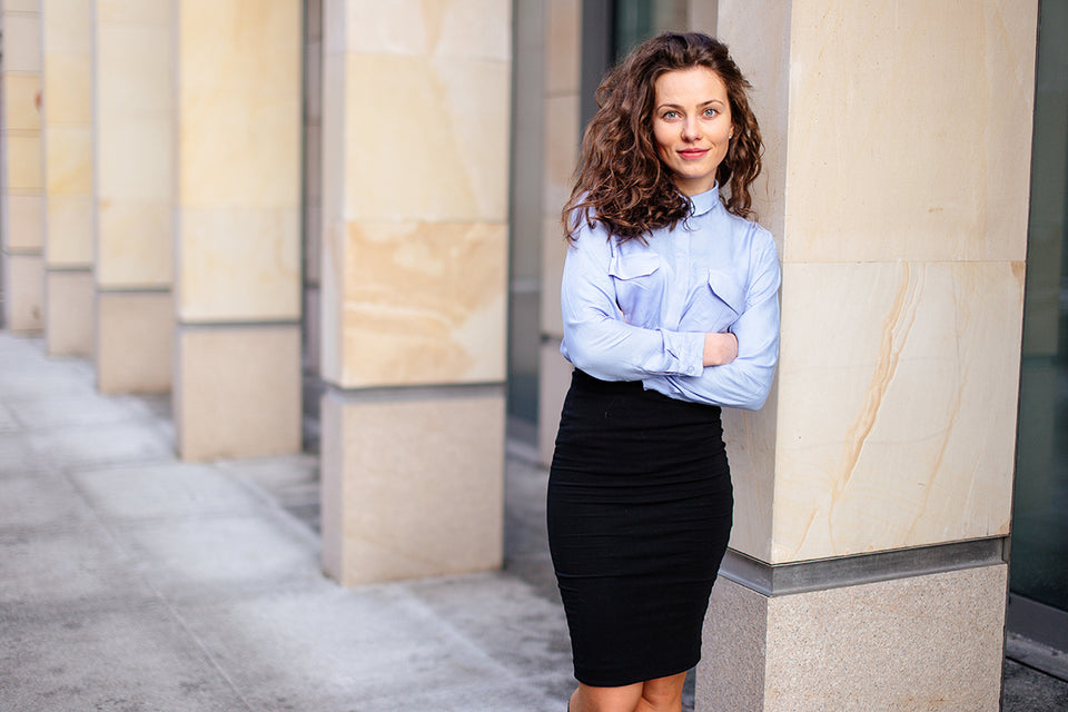 a woman wearing a blue shirt and a black pencil skirt