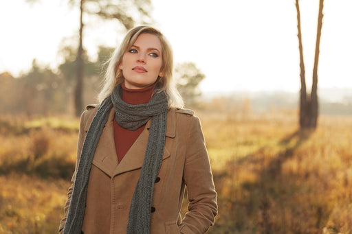 a woman wearing a coat and turtle-neck sweater with a long gray scarf