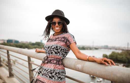 a woman wearing a patterned dress cinched in at the waist