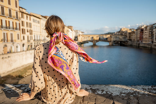 a woman wearing a patterned long scarf wrapped around her ponytail