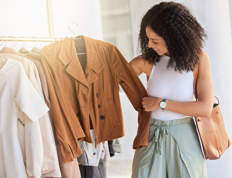 a woman wearing a sage green trouser skirt shopping for clothes