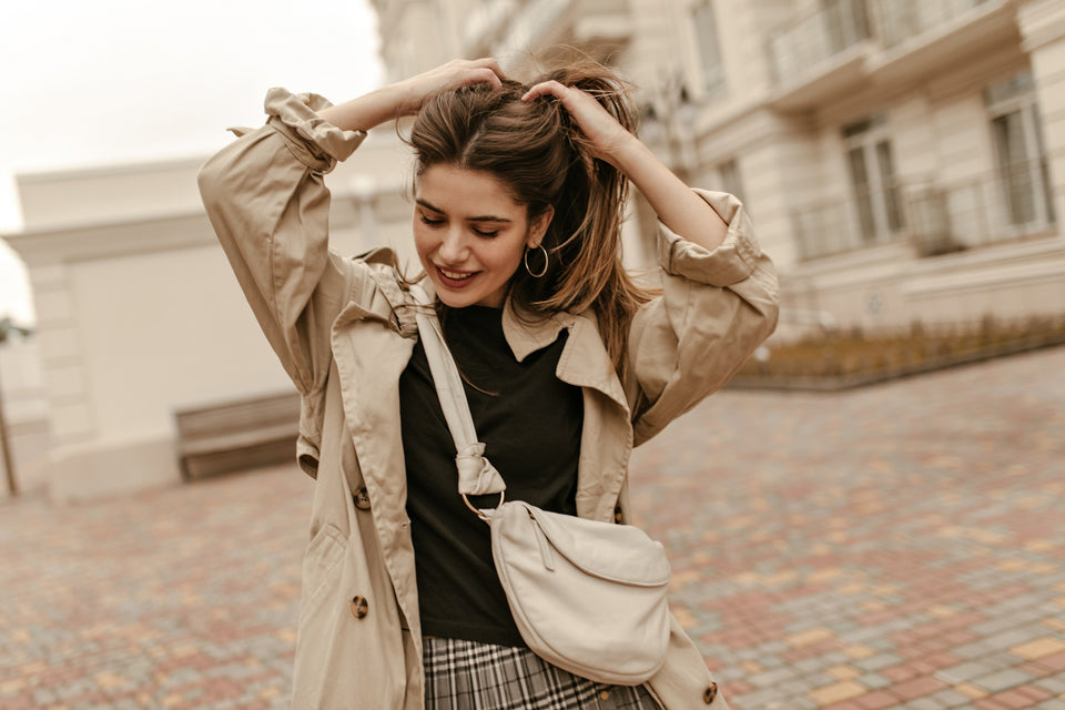 a woman wearing a tan trench coat