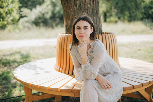 a woman wearing a white cotton lace long sleeved dress