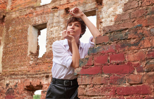 a woman wearing a white shirt with a black leather skirt and belt