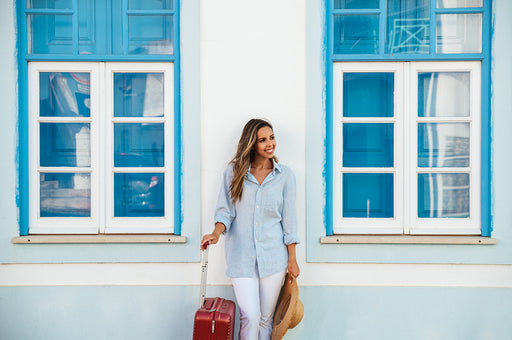 a woman with a suitcase and straw hat