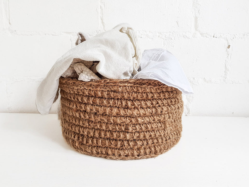 a woven basket full of clothes ready to be washed
