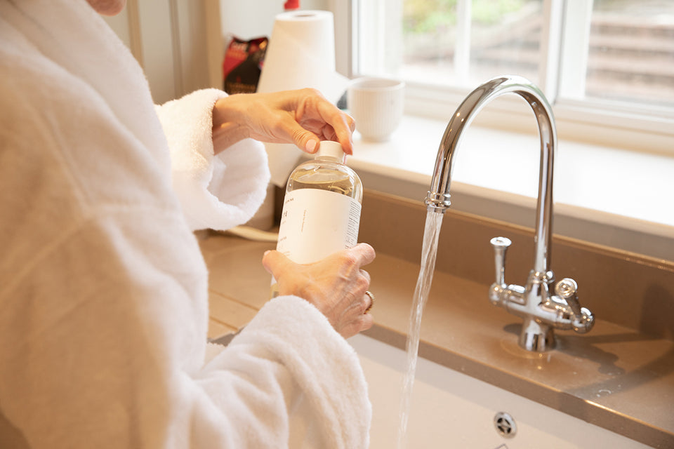 detergent being poured into a laundry sink for hand washing