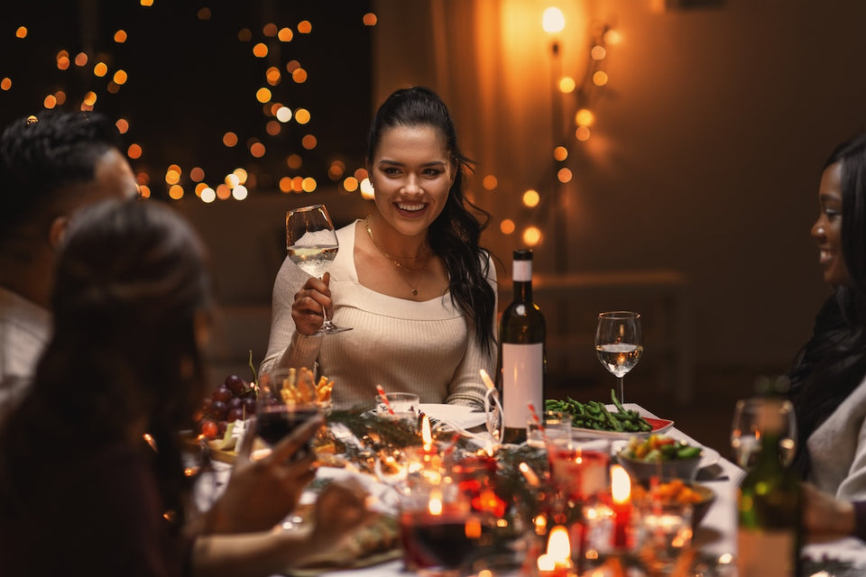 a woman surrounded by friends at a festive dinner table