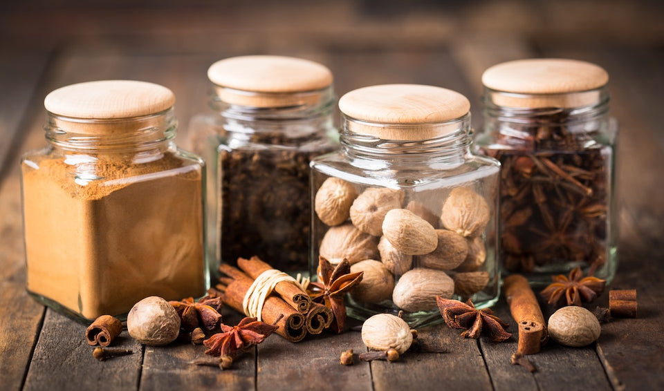glass jars with wooden lids filled with nuts and dried foods