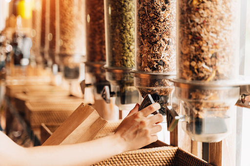 grains and cereals are poured into paper bags from big dispensers in the food store