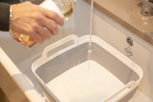 hand washing detergent being poured into a clean sink