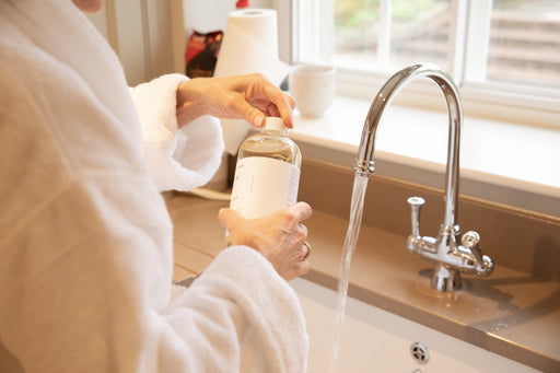 hand washing using a reusable bottle of eco-friendly liquid detergent