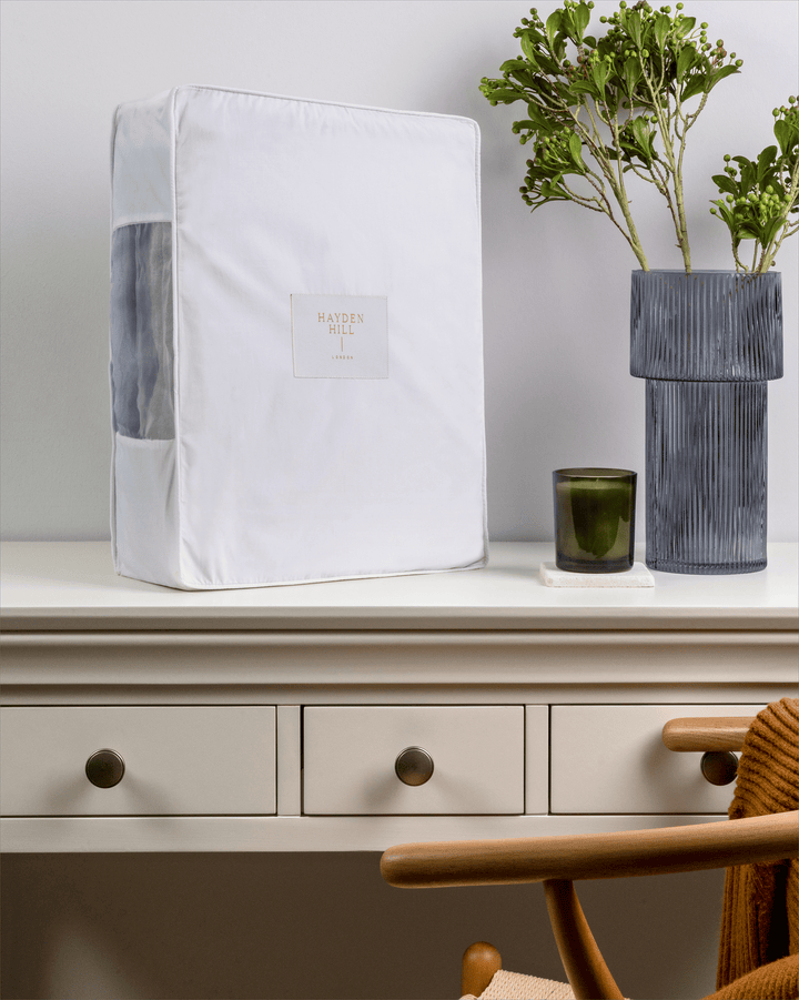 a side view of an extra large storage bag sitting on a dressing table and showing the organza panel