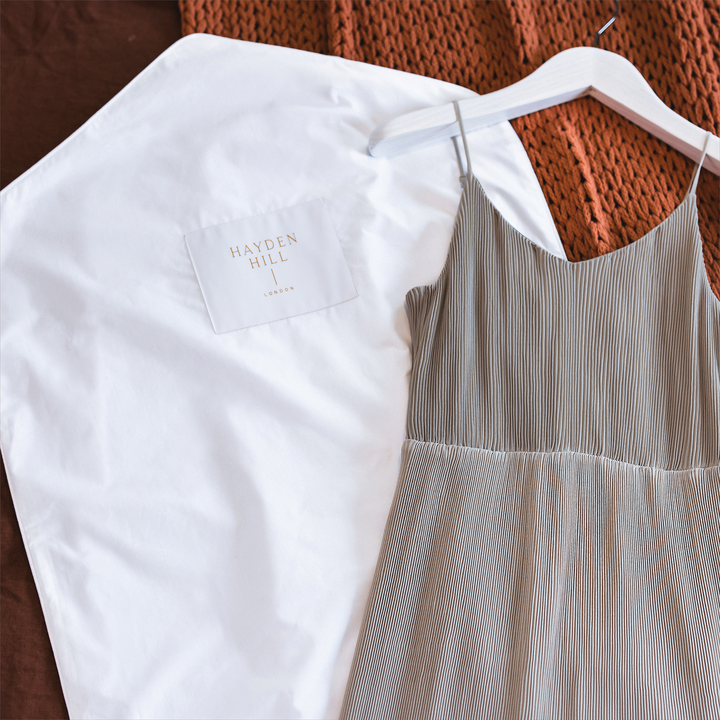 A Hayden Hill hanging bag lying next to  shoestring strap sundress on a woollen blanket