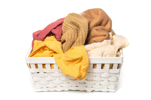 a white laundry basket full of clothing
