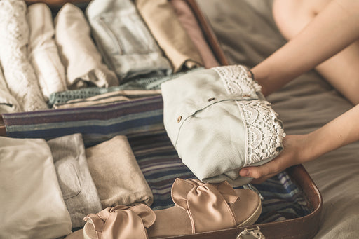 mix and match folded and rolled clothing items being placed in a travel case