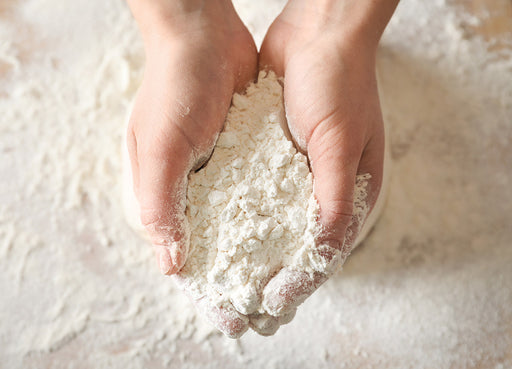 pair of hands holding flour