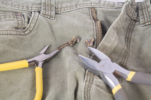 repairing the zip on a pair of pants with pliers