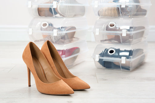 shoes stacked in transparent shoe boxes and a pair of tan pumps
