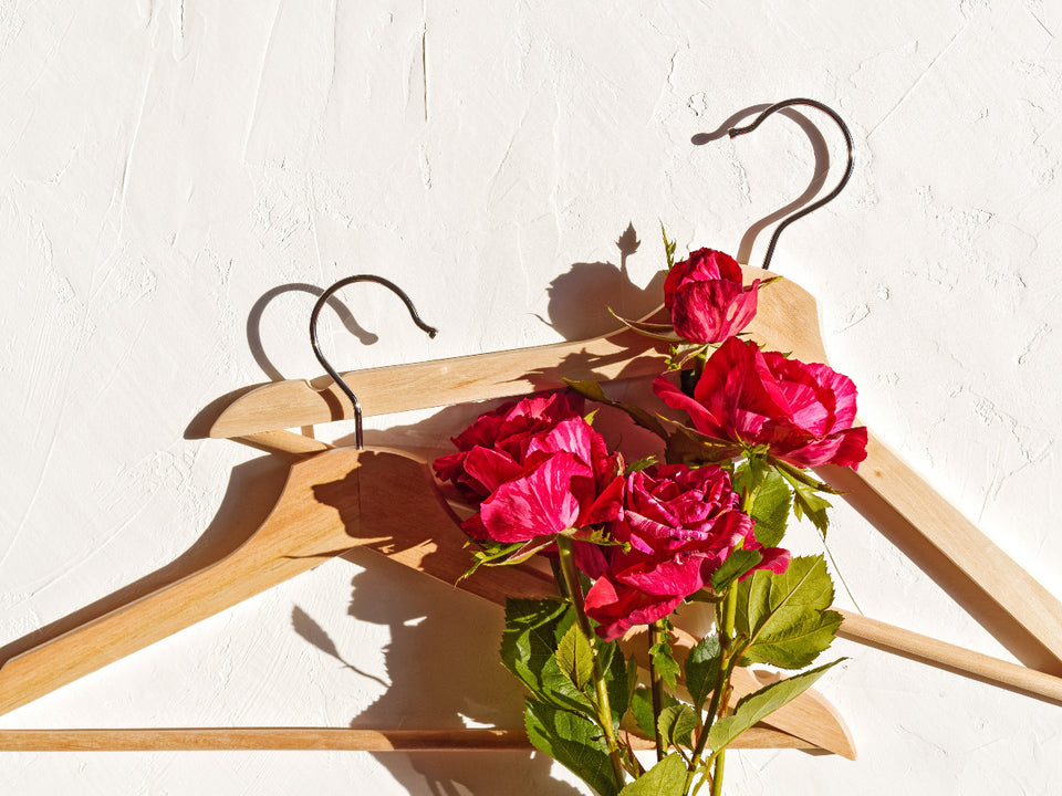 two good quality wooden hangers adorned with red roses