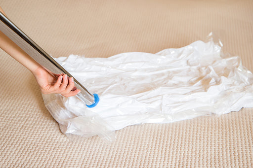 sucking the air from a vacuum storage bag